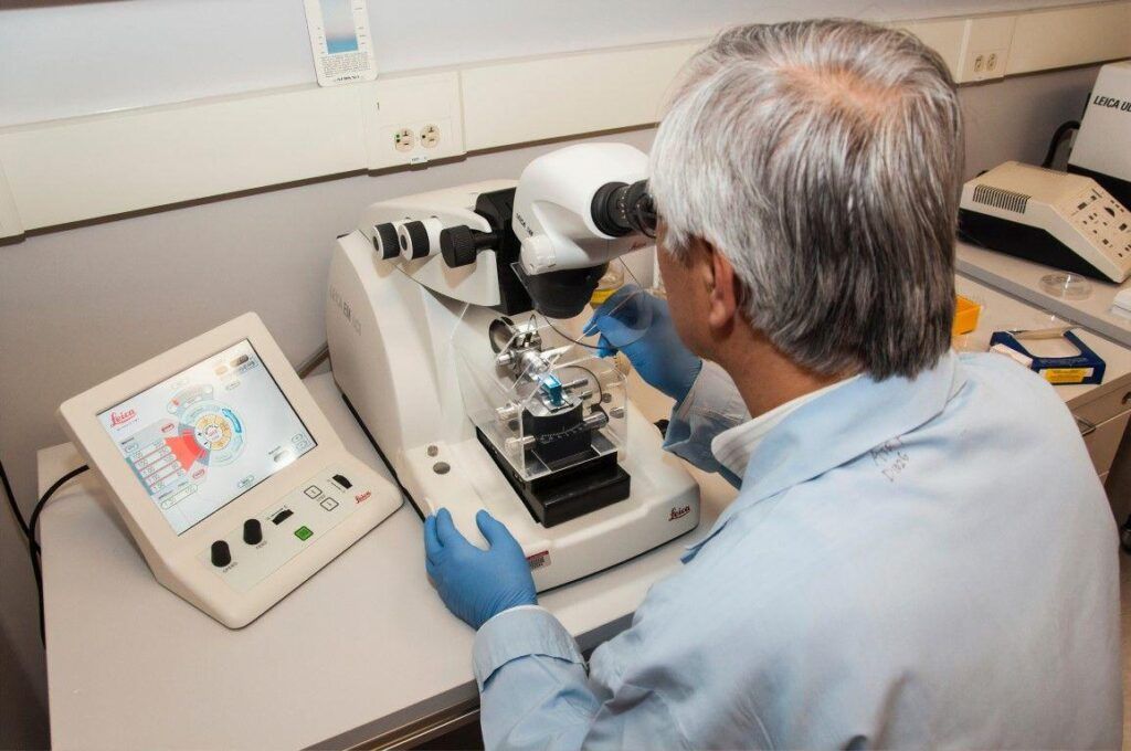 Cientista homem utilizando microscópio